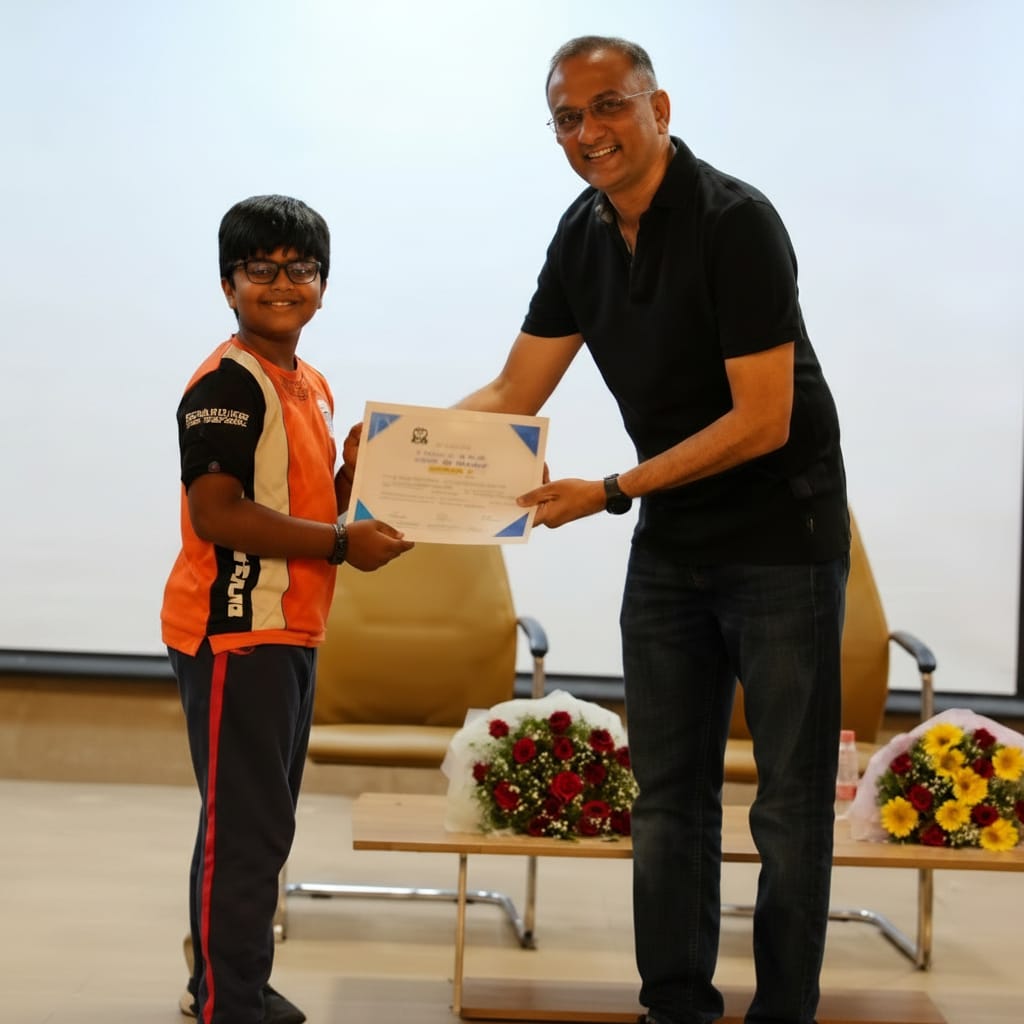 A StrategyM mentor presenting a certificate to a young student on stage