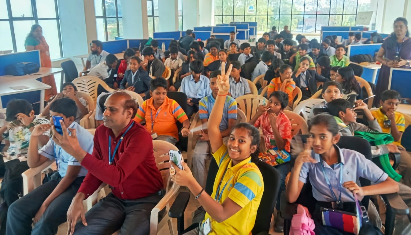 A hall full of students at a StrategyM session, one raising a peace sign to the camera