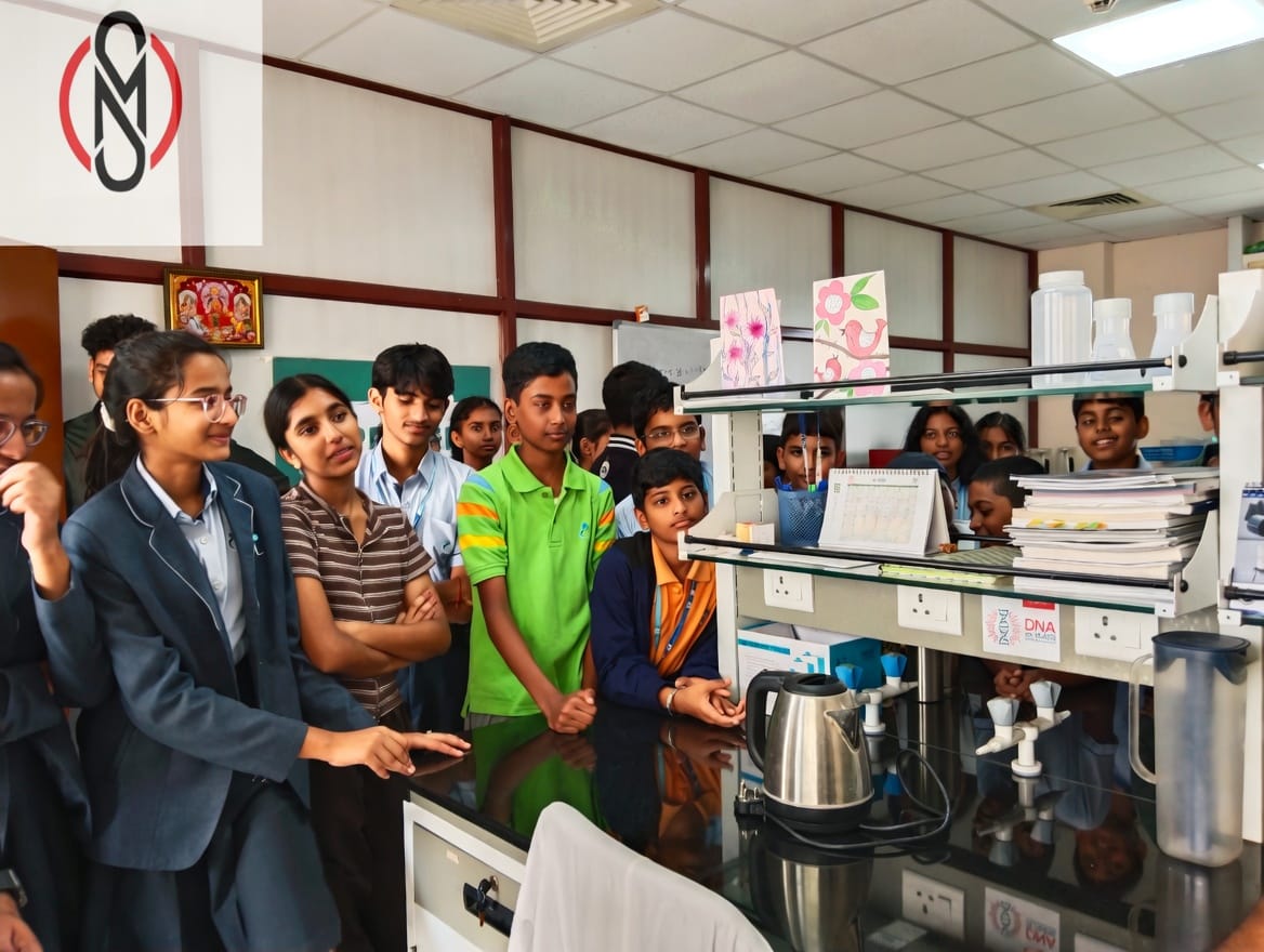 Students gathered around a laboratory bench during a StrategyM industry visit